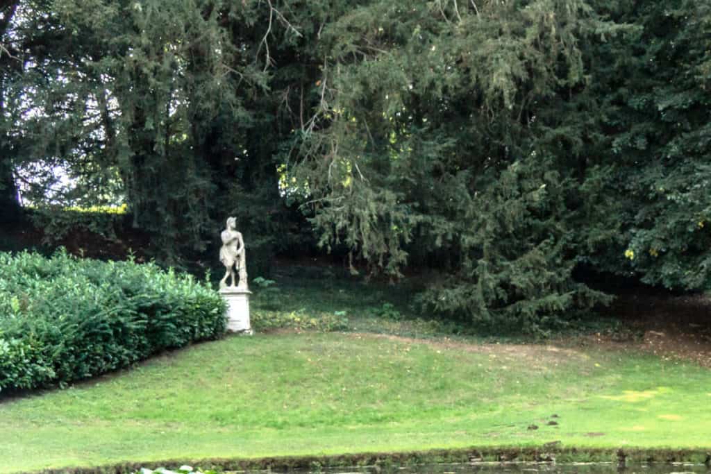 Classical Statue of Faun In Shaded Garden