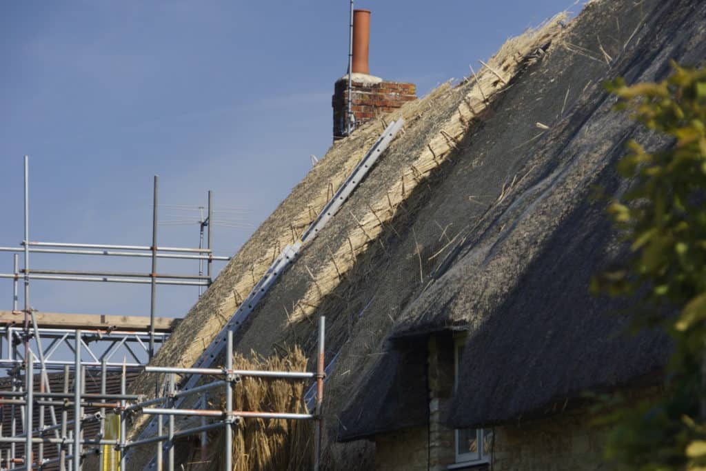 Stone House Having Its Thatched Roof Repaired