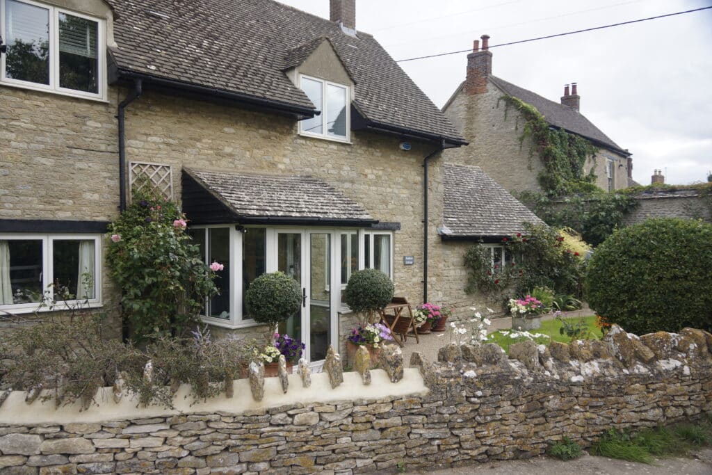 Canalside house in Thrupp Village, surrounded bt planters of flowers