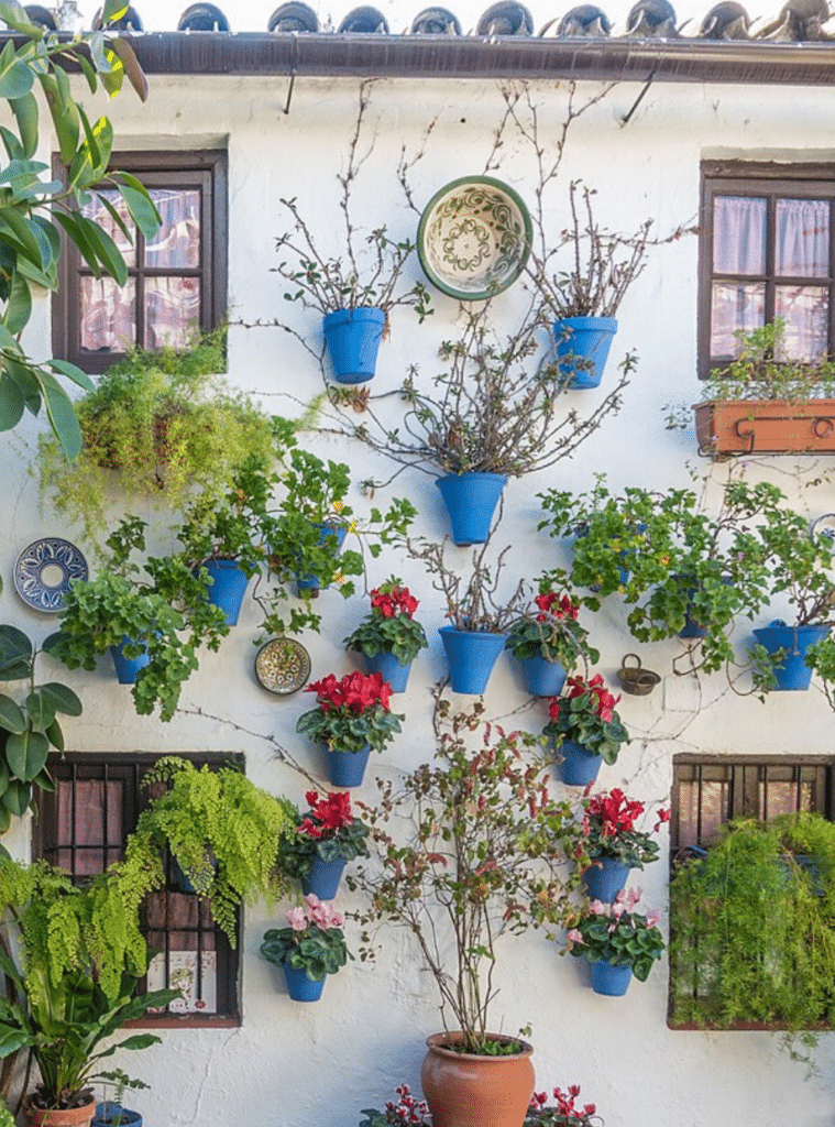 White Spanish wall with turquoise flower pots, four small windows, and a row of barrel tiles at the top.