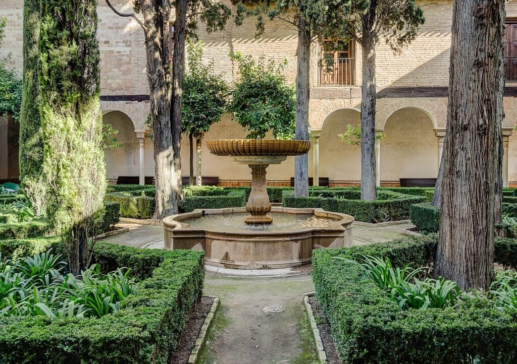 Nasrid courtyard garden with central fountain, hedges, and shaded arcades that influenced the development of Spanish patio gardens