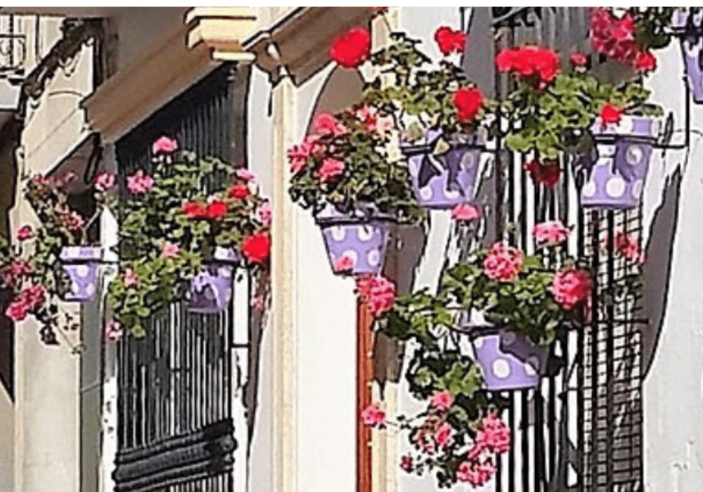 Lavender polka‑dot flower pots hanging on a white wall in Estepona, Spain.