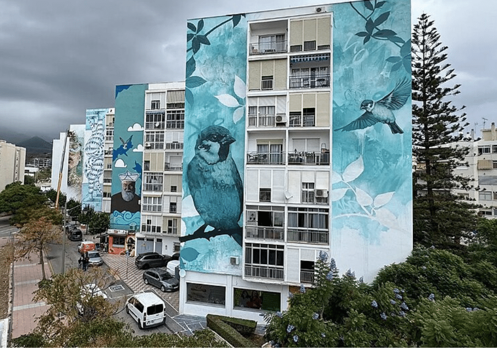 Multi story buildings decorated in images flowers, birds and even humans.